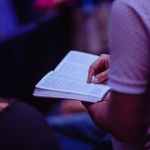 selective focus photo of person holding book