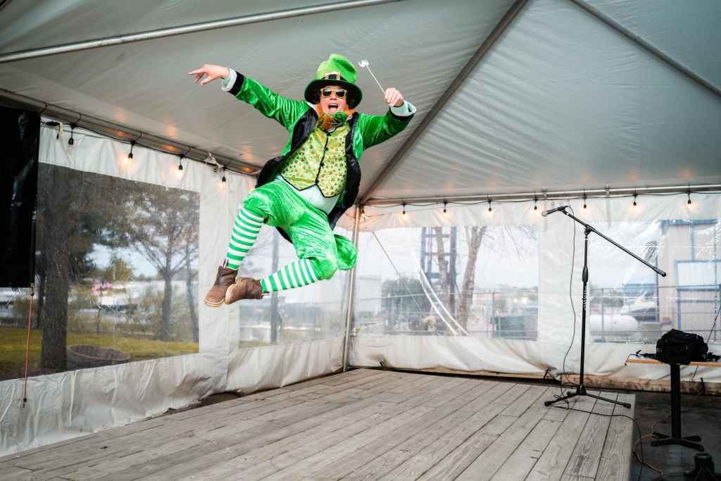 cheerful anonymous circus artist in colorful costume jumping in tent