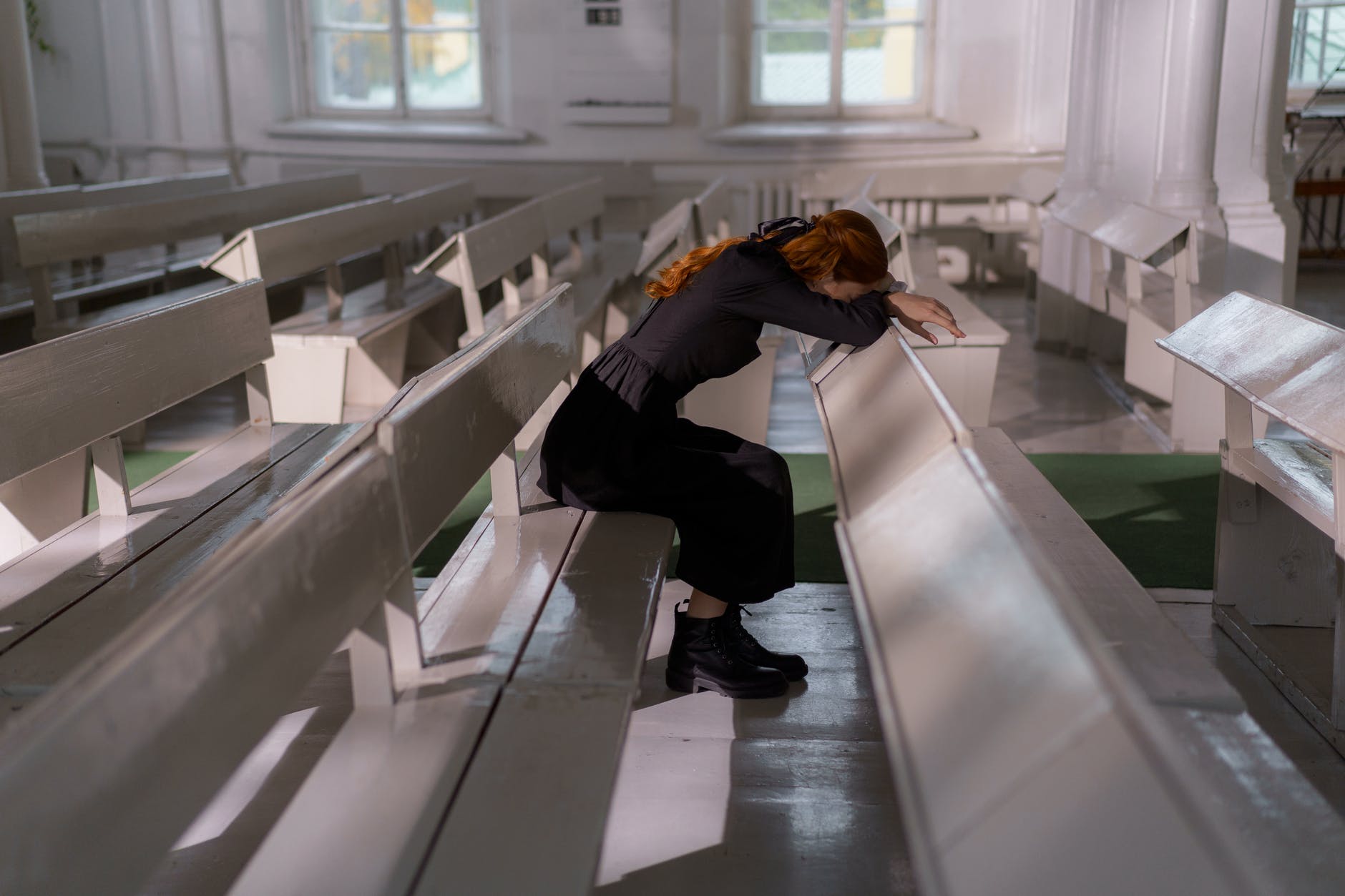woman in black jacket and black pants sitting on white staircase