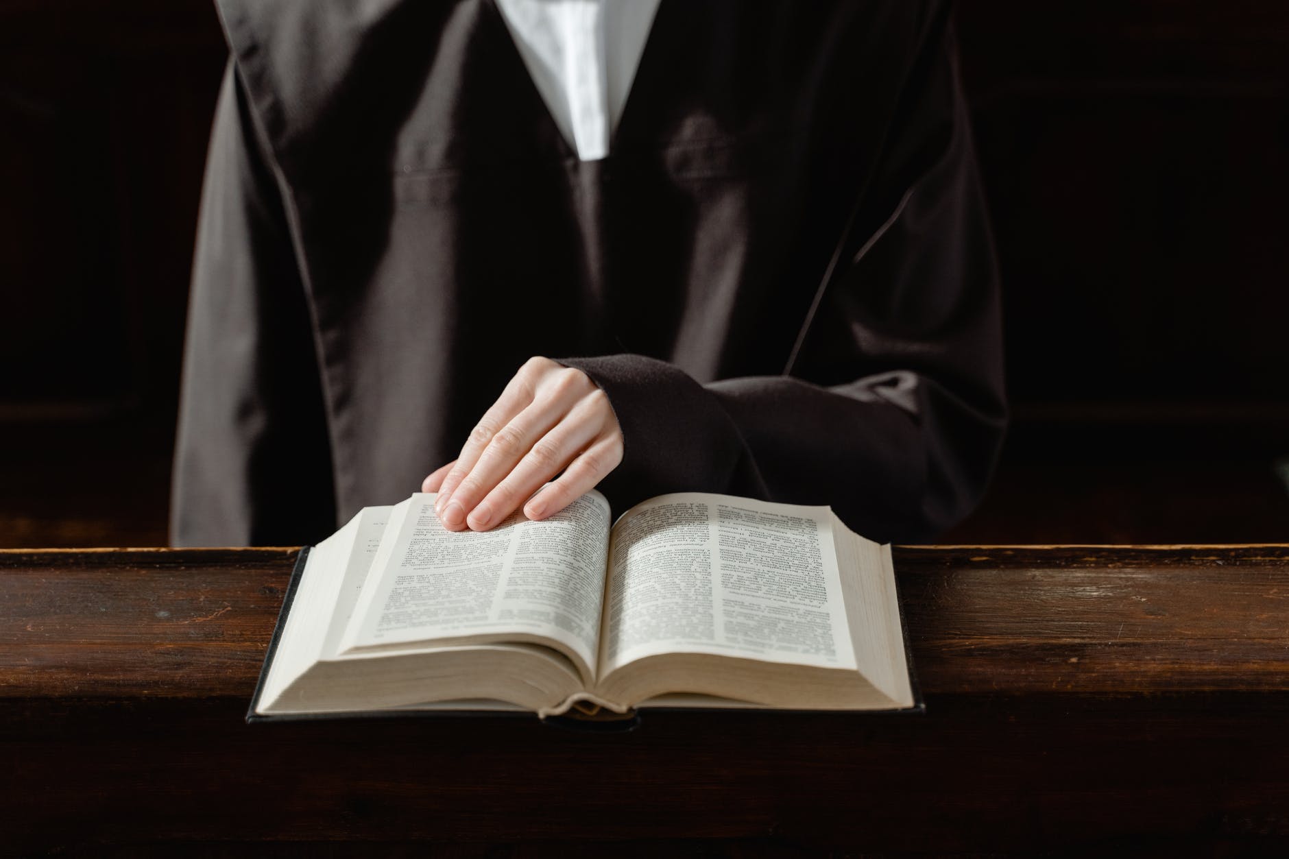 person reading book on brown wooden table