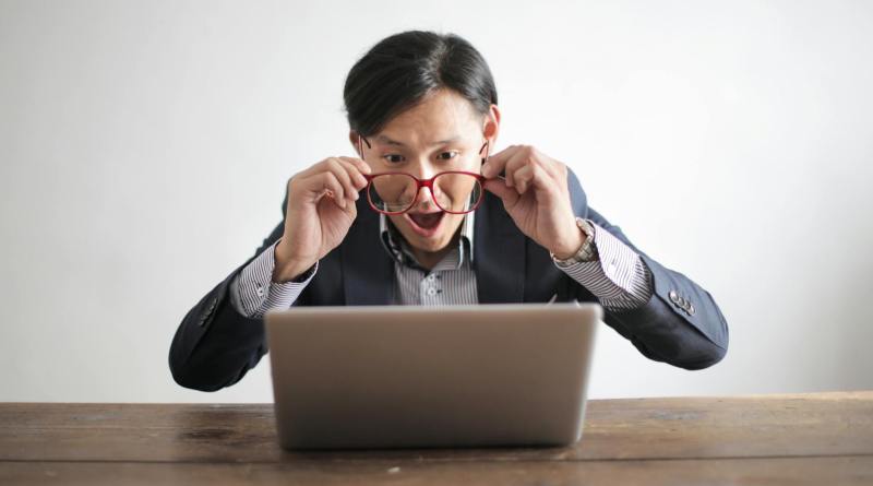 amazed formal male looking at laptop screen