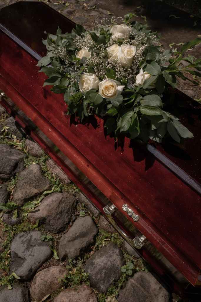 white flowers on the top of a coffin