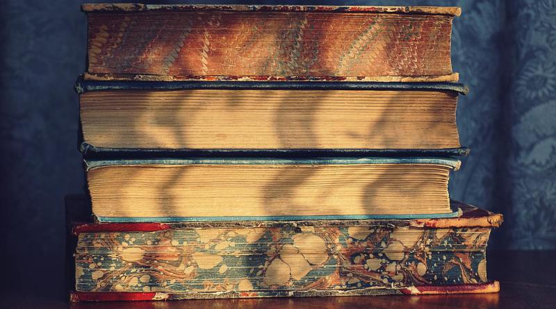 four pile of books on top of brown wooden surface
