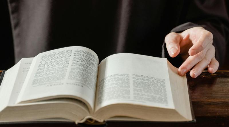 person reading book on brown wooden table