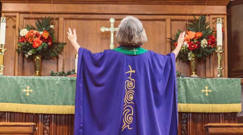 priestess with hands raised standing on the altar