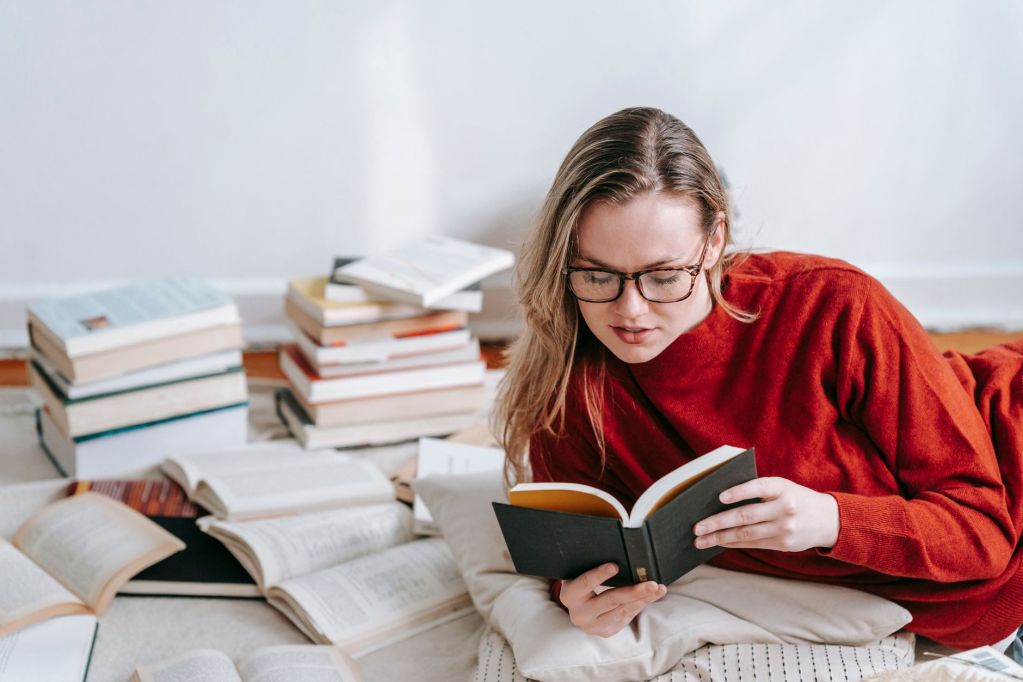 thoughtful woman near heap of books